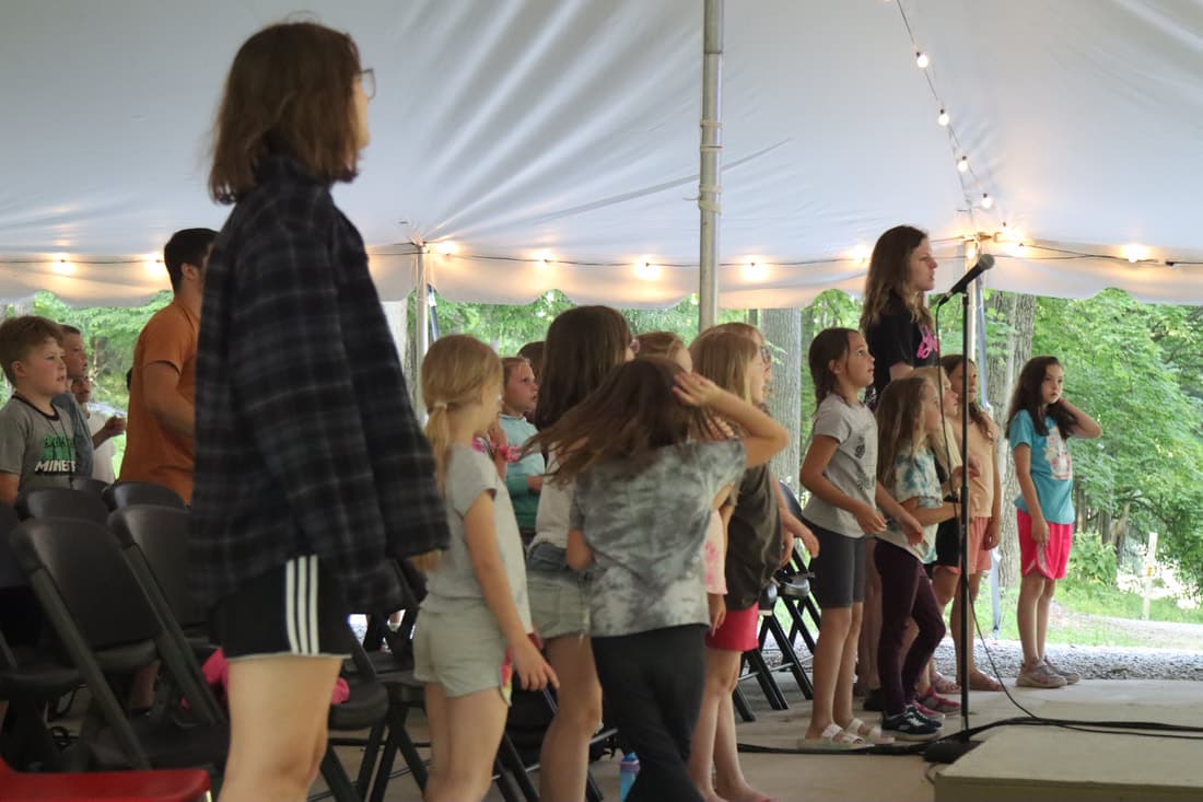 Worship leader leading music during chapel at Camp Otyokwah